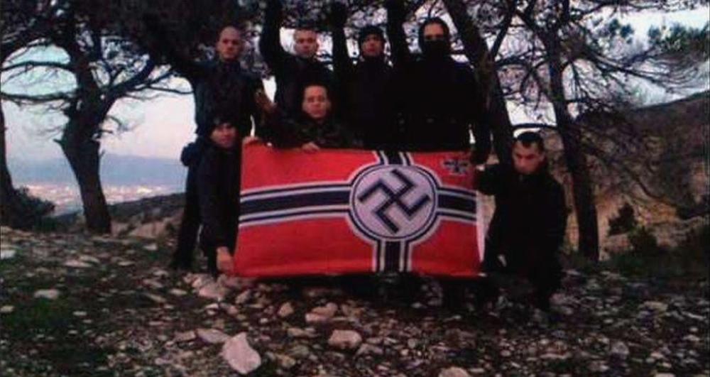 2012-12-21%20Ilias%20Kasidiaris%20posing%20in%20the%20center%20alongside%20other%20GD%20members%20with%20a%20Nazi%20Wehrmacht%20flag%20during%20the%20Winter%20Solstice%20in%20Greece_0.jpg